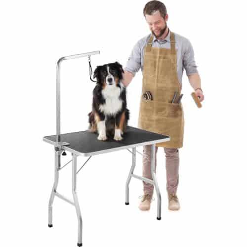 man trimt een hond op een trimtafel